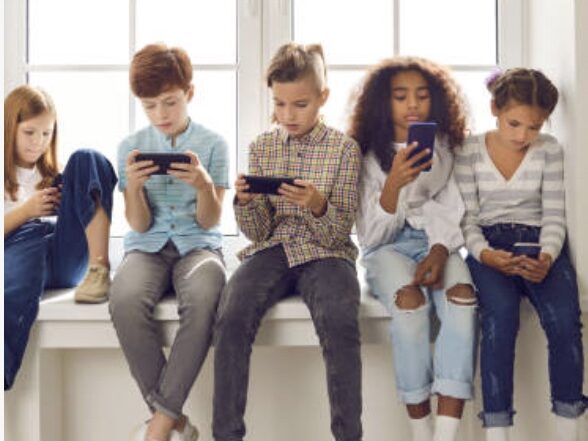 kids on smart phones hanging out but not engaging with each other