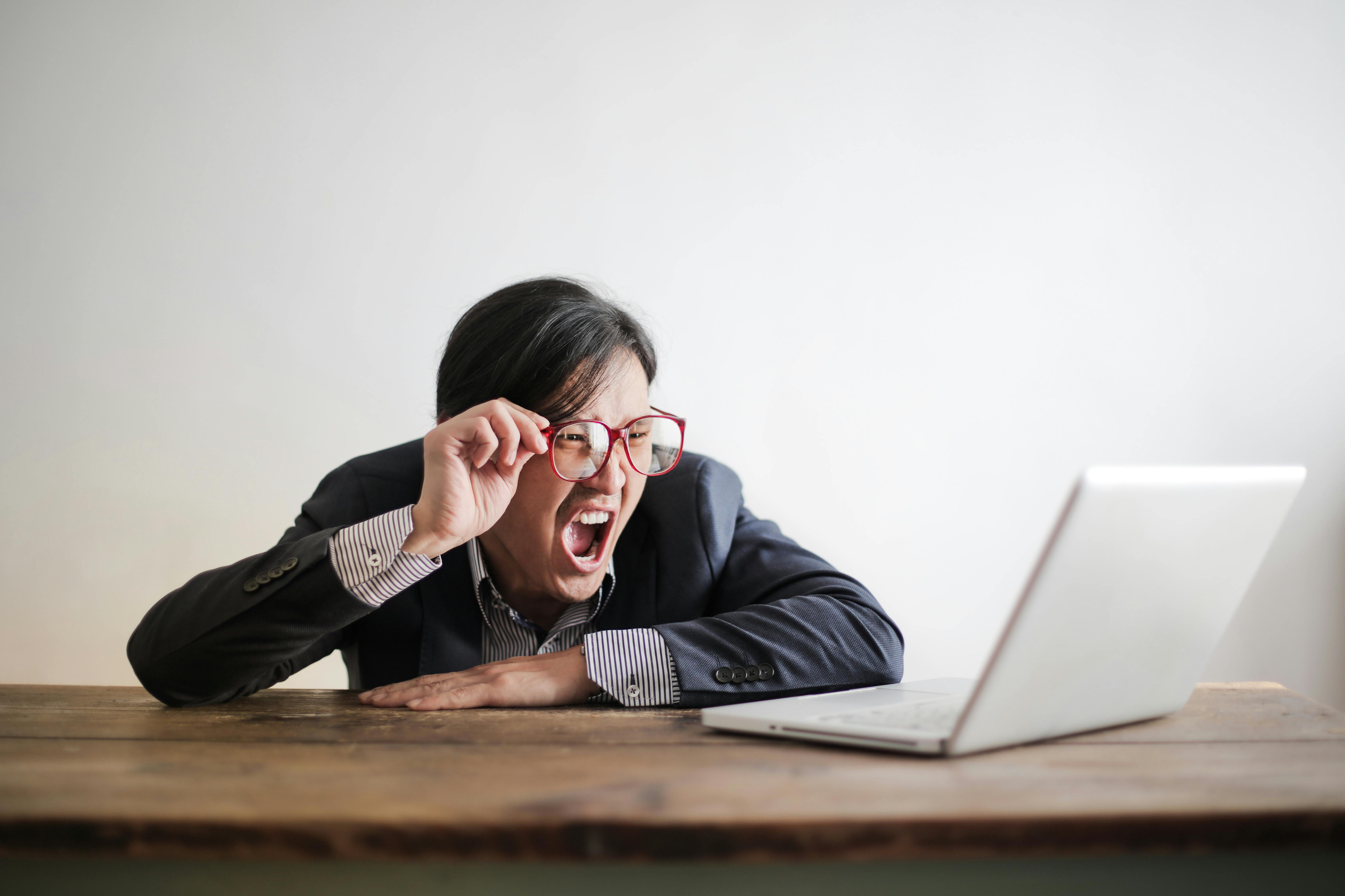 man looking at computer and yelling